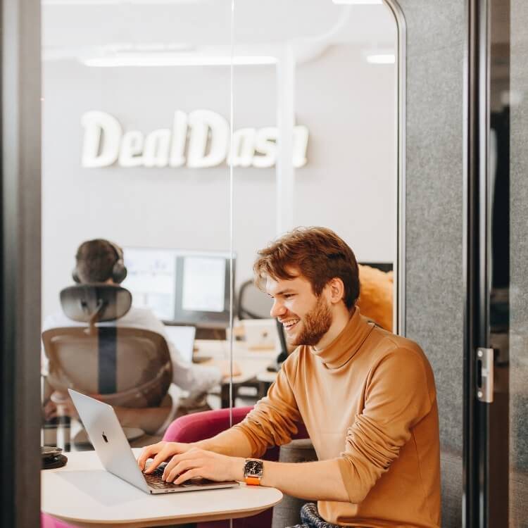 A DealDash team member at a laptop in the office